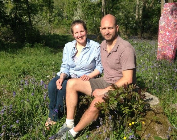 Couple setting on the grass.
